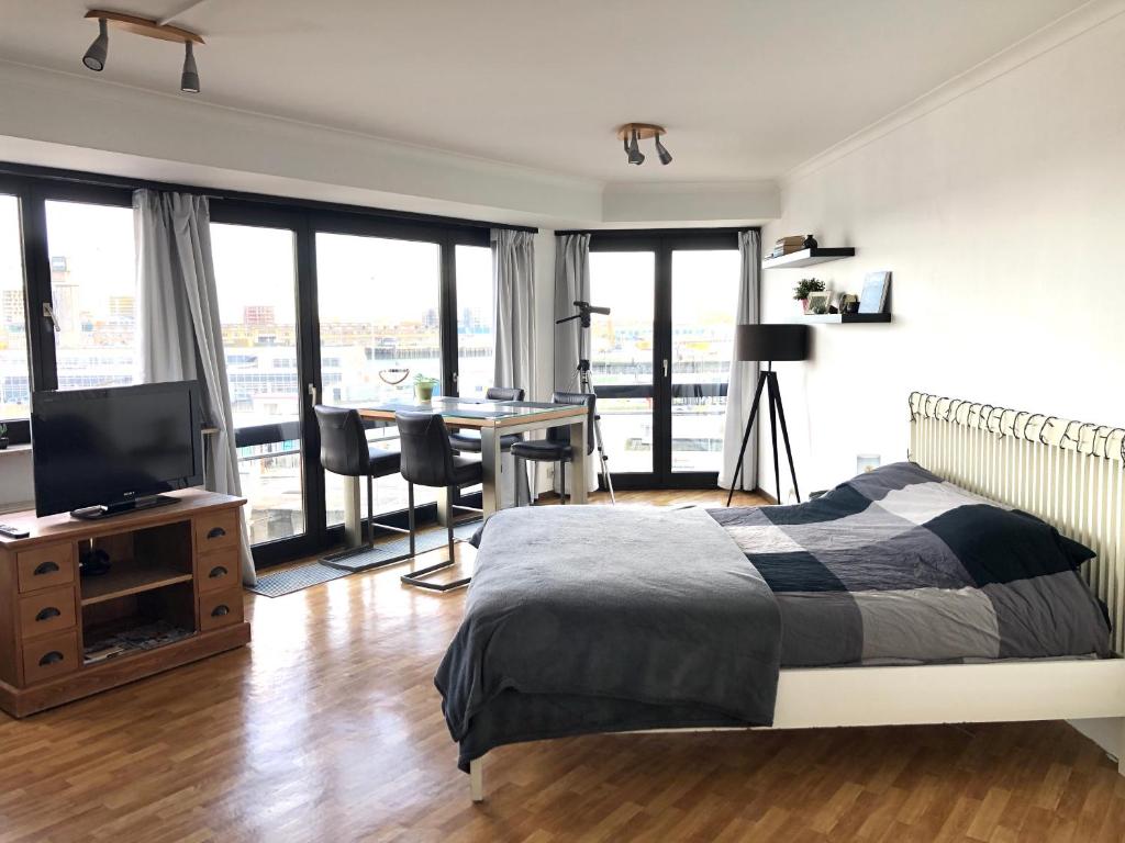 オーステンデにあるCosy, modern studio with an awesome view of Ostendのベッドルーム1室(ベッド1台、デスク、テレビ付)