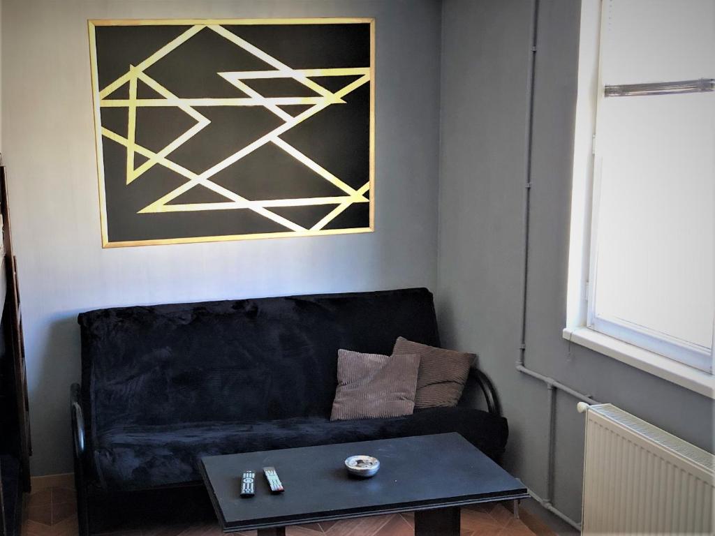 a living room with a black couch and a table at Marco Polo, Mountain View Apartment in Gudauri