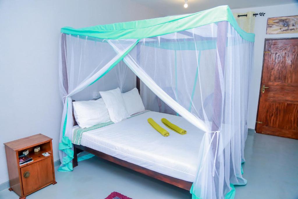 a bedroom with a canopy bed with two bananas on it at Greenery Lanka Villa in Unawatuna