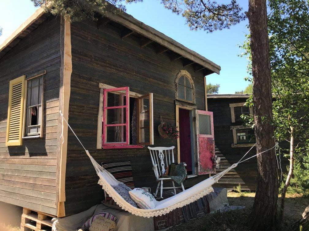 un hamac suspendu à l'extérieur d'une maison avec une chaise dans l'établissement Fide Äventyrsby & Camping, à Fidenäs