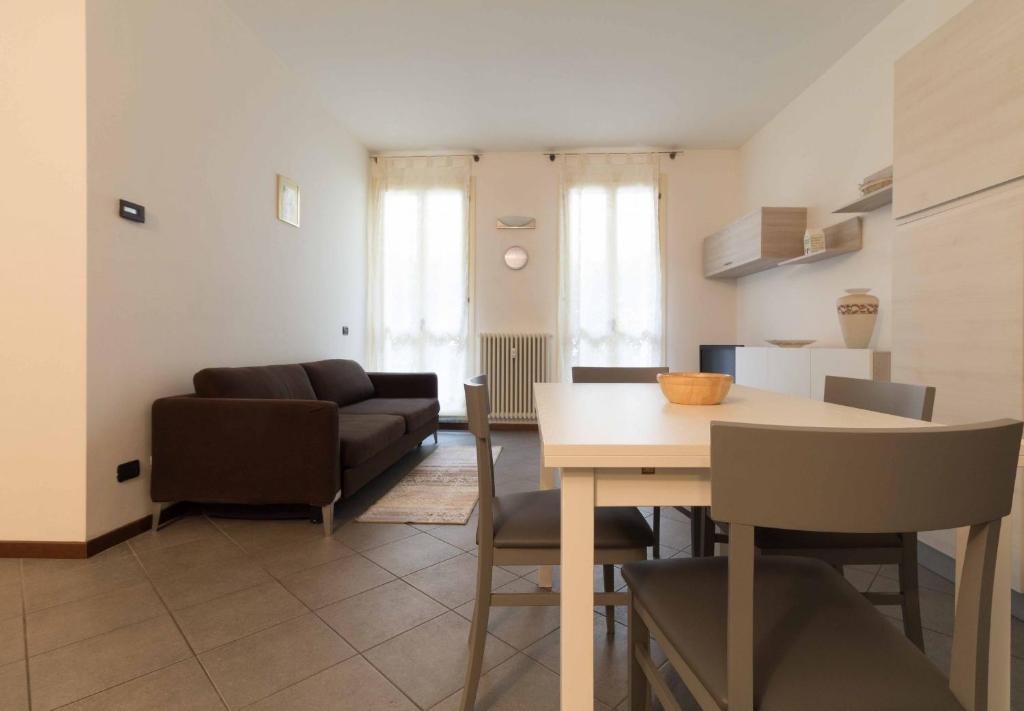 sala de estar con mesa y sofá en Galleria Roma Apartment - Affitti Brevi Italia, en Lecco