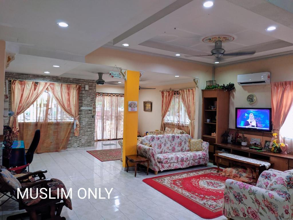 a living room with a couch and a tv at Homestay Mamasya Melaka in Melaka