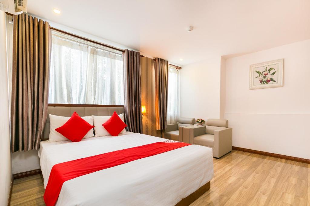 a bedroom with a large bed with red pillows at Hung Phat Hotel - Trung Son in Ho Chi Minh City