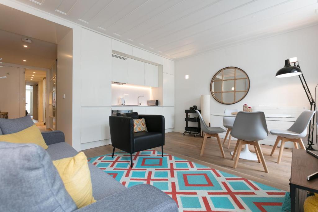 een woonkamer met een bank, stoelen en een tafel bij FLH Chiado Modern Place in Lissabon