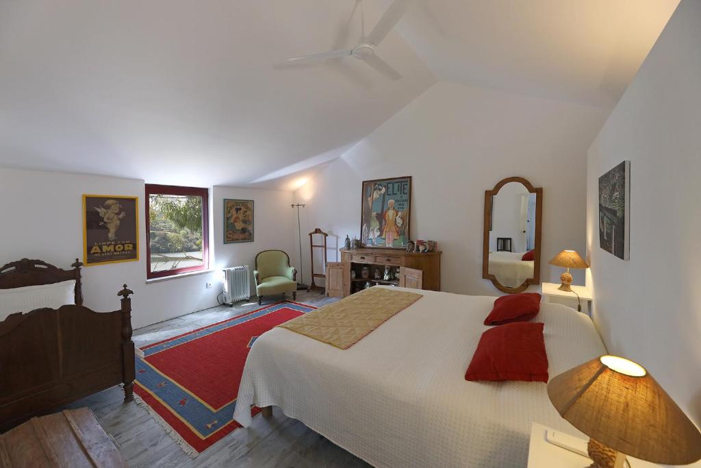 een slaapkamer met een groot wit bed en een woonkamer bij Quinta da Ferradosa Wines in São João da Pesqueira