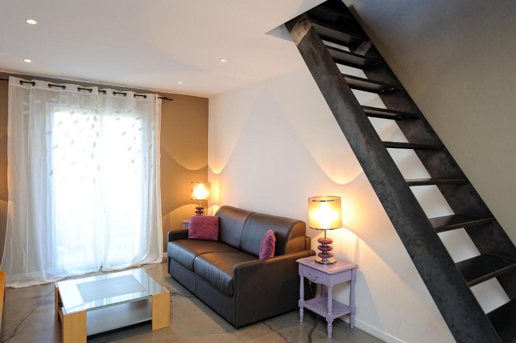 a living room with a couch and a staircase at Appartement du Tourisme in Zonza