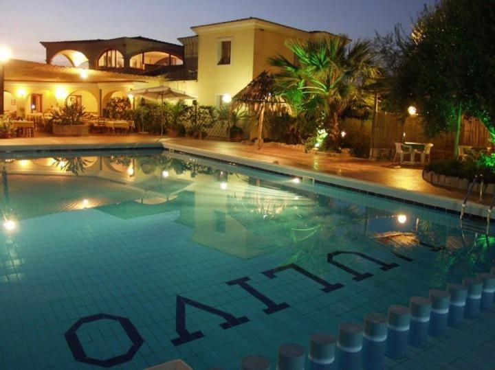 a swimming pool in front of a house at night at Hotel L'Ulivo in Girasole