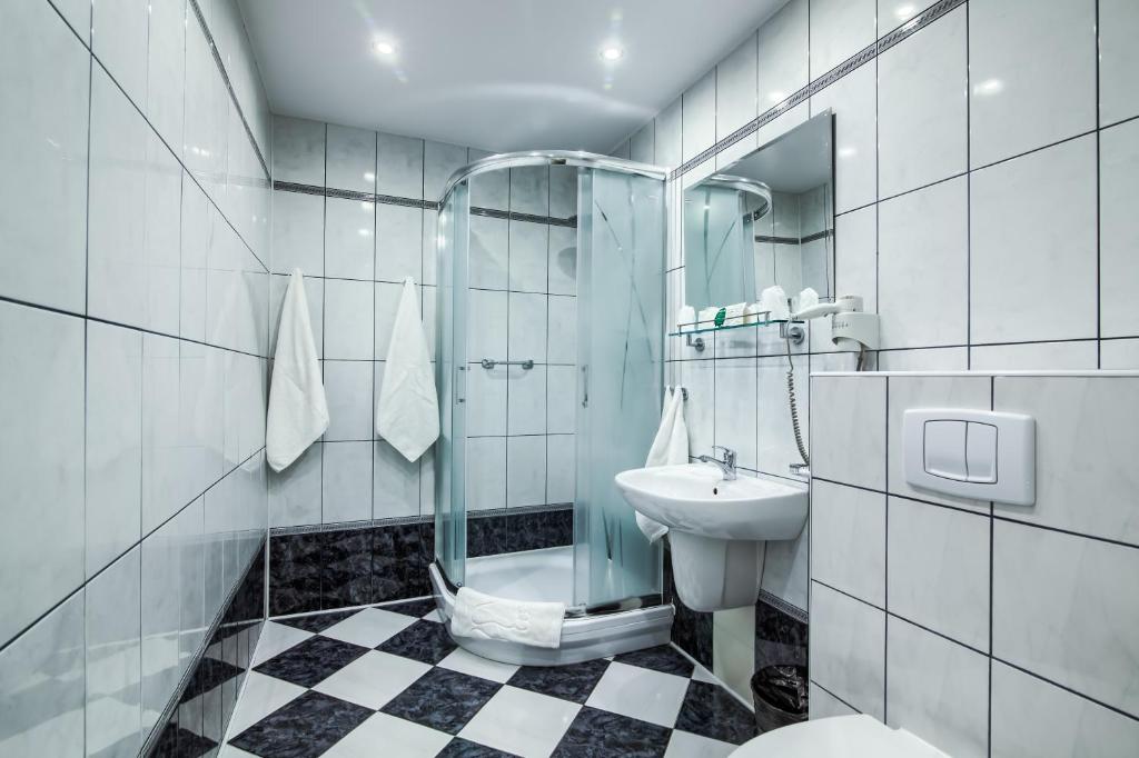 W łazience znajduje się prysznic, umywalka i toaleta. w obiekcie Hotel Konin w Koninie