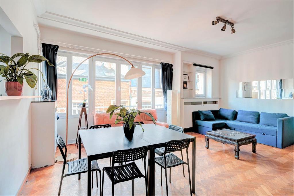 ein Wohnzimmer mit einem Tisch und einem blauen Sofa in der Unterkunft Cozy Apartment on Best Location in Antwerp in Antwerpen