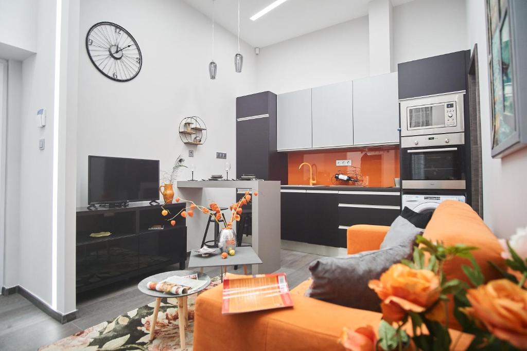 een woonkamer met een oranje bank en een keuken bij W18 Design Apartments - Budapest Downtown in Boedapest