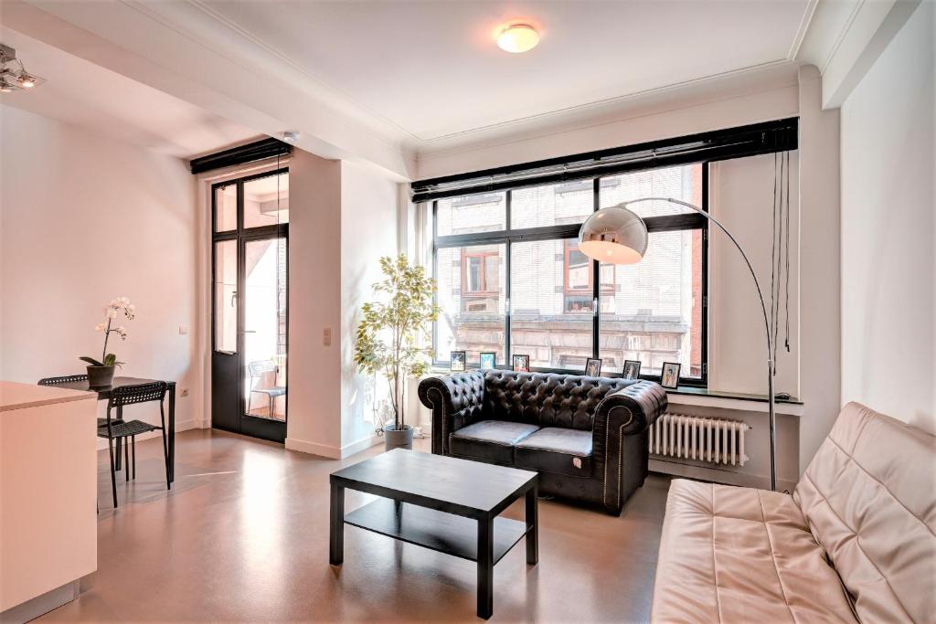 een woonkamer met een bank en een tafel bij The Meir Lodge. Apartments in heart of Antwerp in Antwerpen