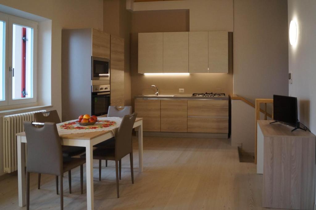 cocina y comedor con mesa y sillas en Appartamenti Il Cerbiatto, en Cavedago