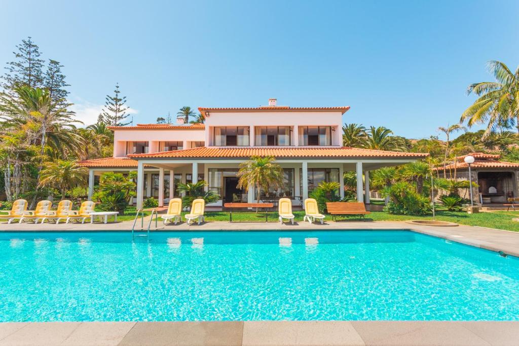 a house with a swimming pool in front of a house at FLH Luxury Villa Mar with Private Sea Access in Caniçal