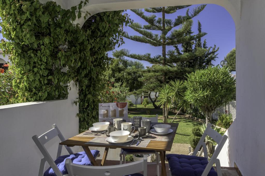 einen Tisch und Stühle auf einer Terrasse mit einem Baum in der Unterkunft FLH Gaivotas Cozy House in Porches