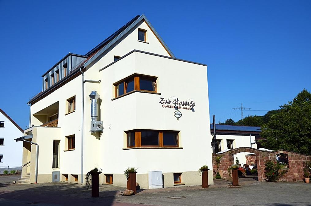 un edificio blanco con un cartel en el costado en Quartier-Restaurant Zum Hannes en Niederhausen