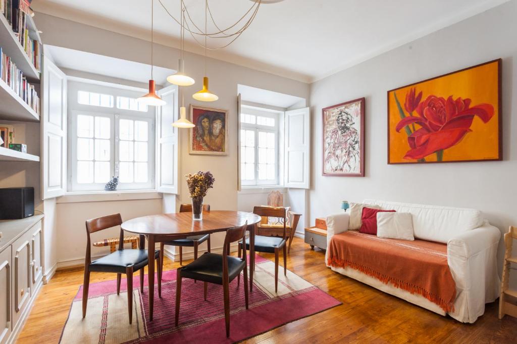 ein Wohnzimmer mit einem Tisch und einem Sofa in der Unterkunft FLH Janelas Verdes Charming Flat in Lissabon