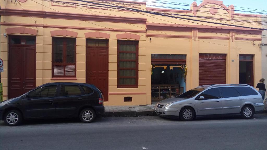 two cars parked in front of a building at Morada do Estudante in Pelotas