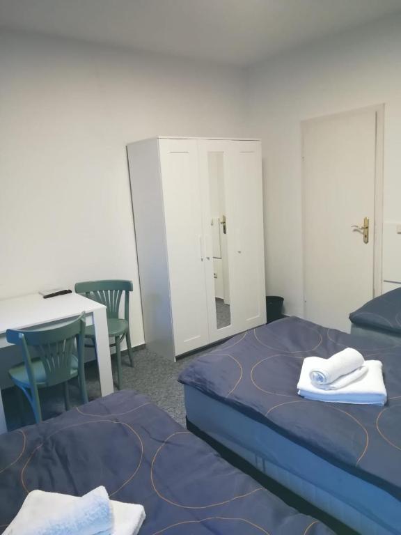 a room with two beds and a table and a mirror at Kunstgasse 11 Wohnung 8 in Altenburg