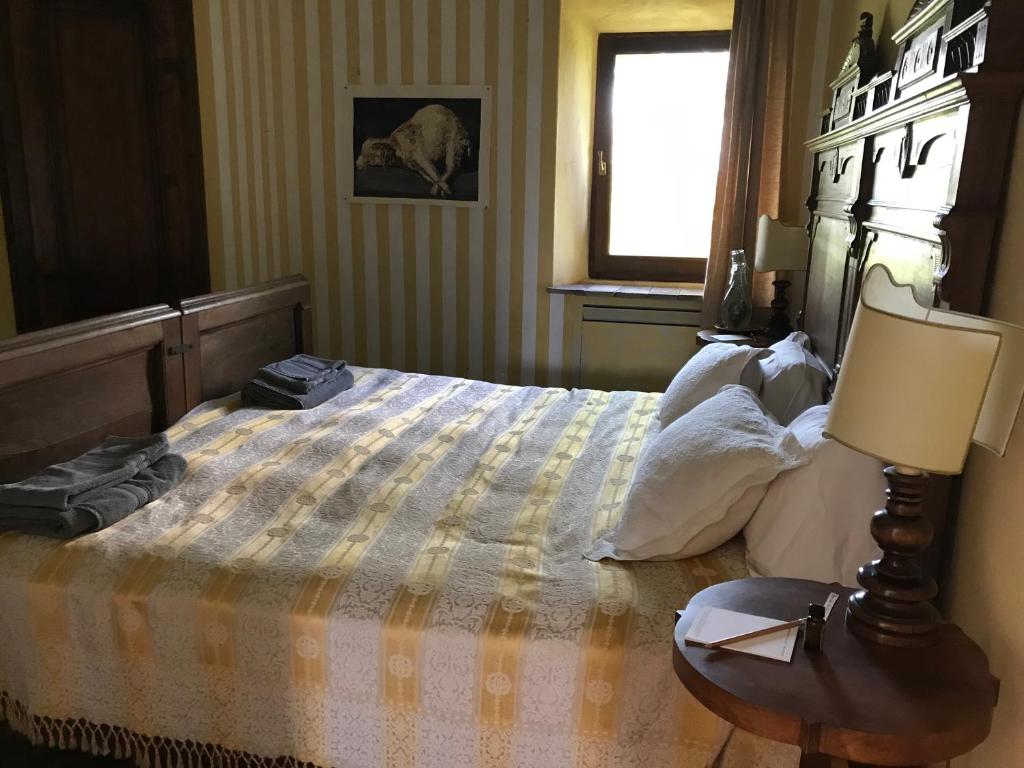 una camera con letto, lampada e finestra di Il Convento a Pitigliano