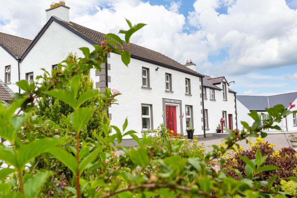 a row of white houses with a red door at Willow House Bed & Breakfast and Orchard Studios Self Catering in Limavady