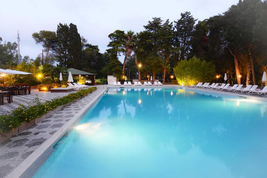 una gran piscina de agua azul por la noche en Villaggio Camping Sentinella, en Torre dell'Orso