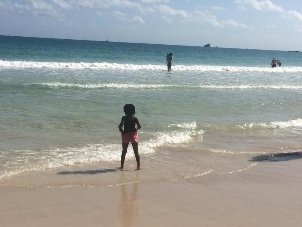 a young child standing on the beach near the ocean at Cliff haven in Borth