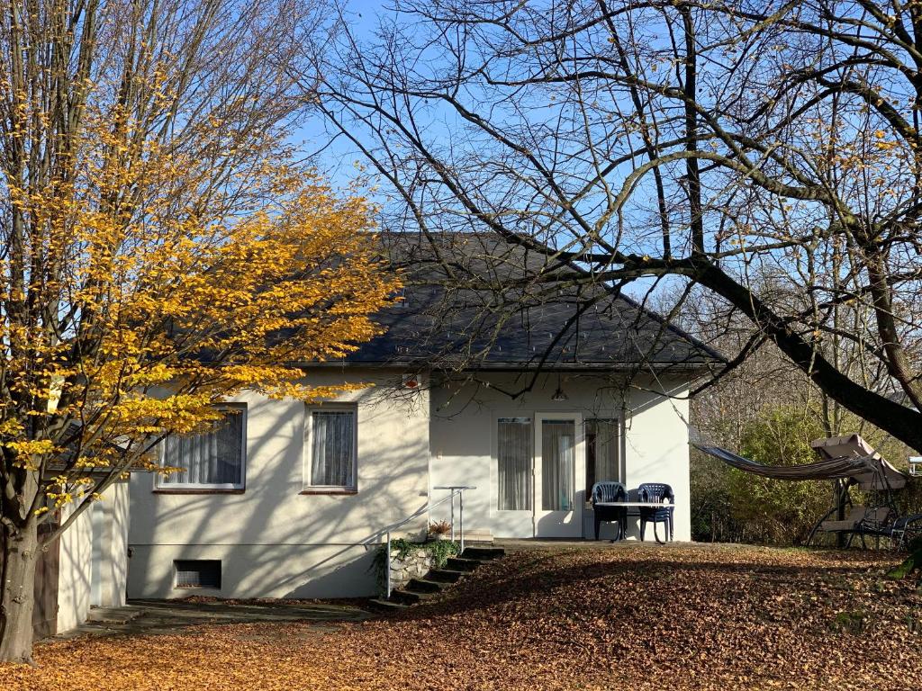 Una casa blanca con un árbol delante. en NED Haus en Feldkirchen bei Graz