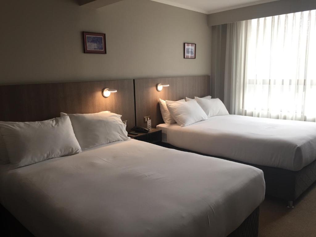 Postel nebo postele na pokoji v ubytování OHiggins Park Hotel