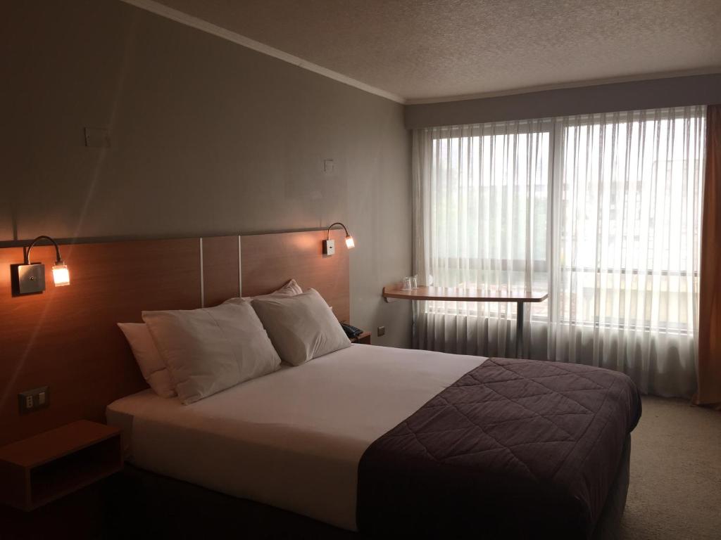 Postel nebo postele na pokoji v ubytování OHiggins Park Hotel