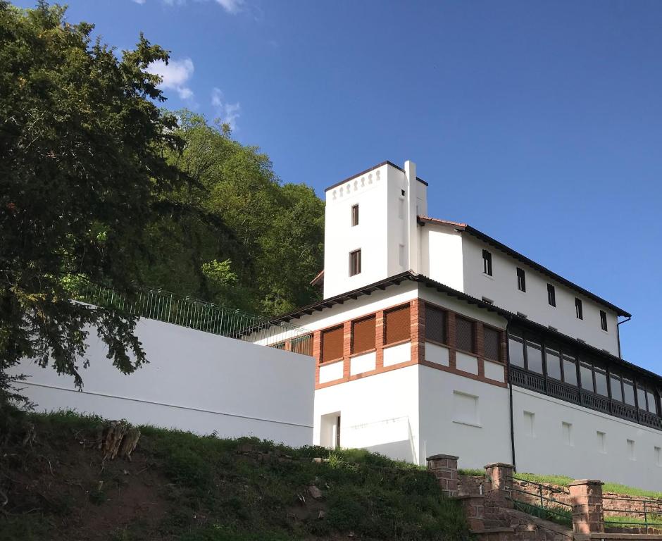 un bâtiment blanc au sommet d'une colline dans l'établissement Domaine du Haut-Koenigsbourg, à Orschwiller