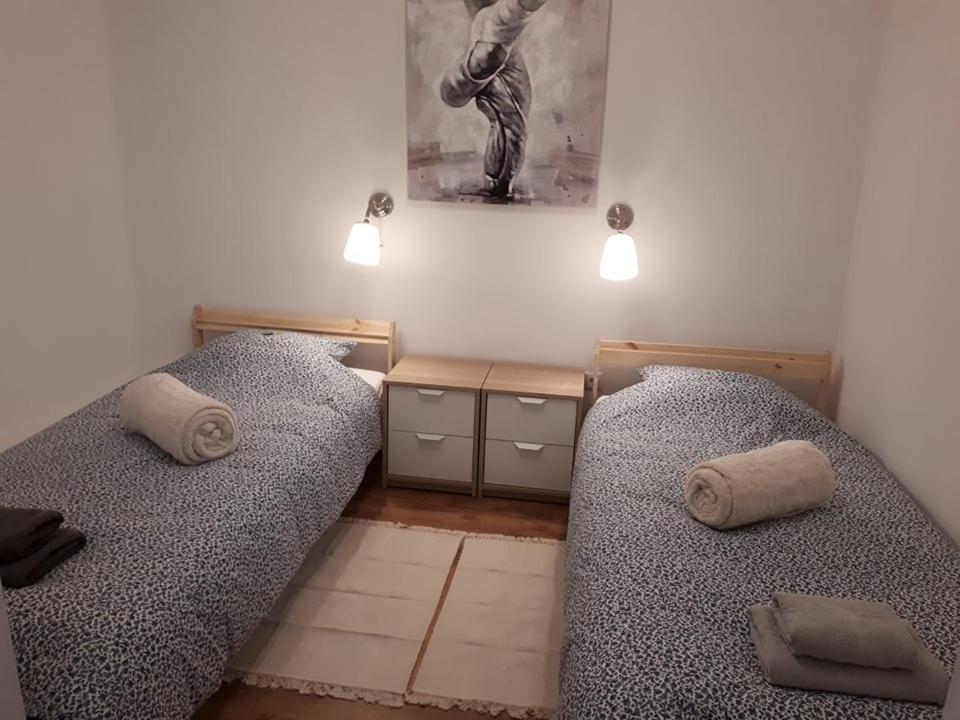 dos camas sentadas una al lado de la otra en una habitación en Apartman ANA, en Slavonski Brod