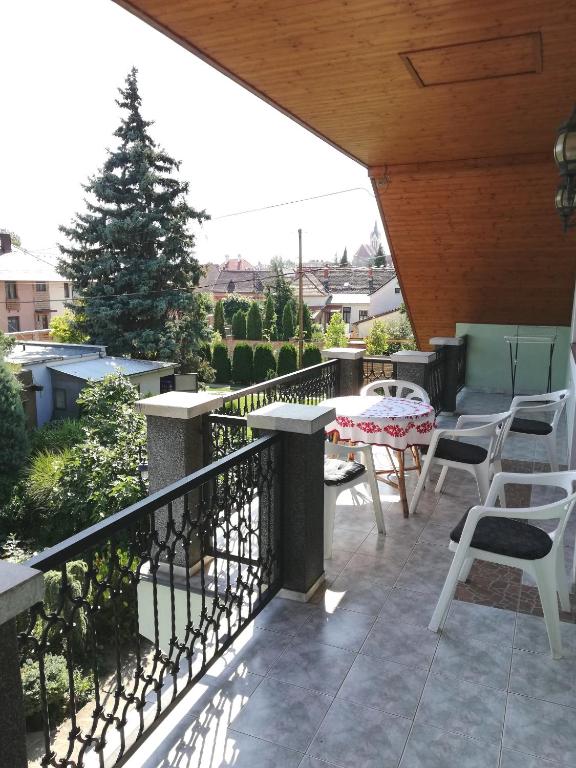 balkon z krzesłami, stołem i drzewem w obiekcie Édenkert Apartman w mieście Keszthely