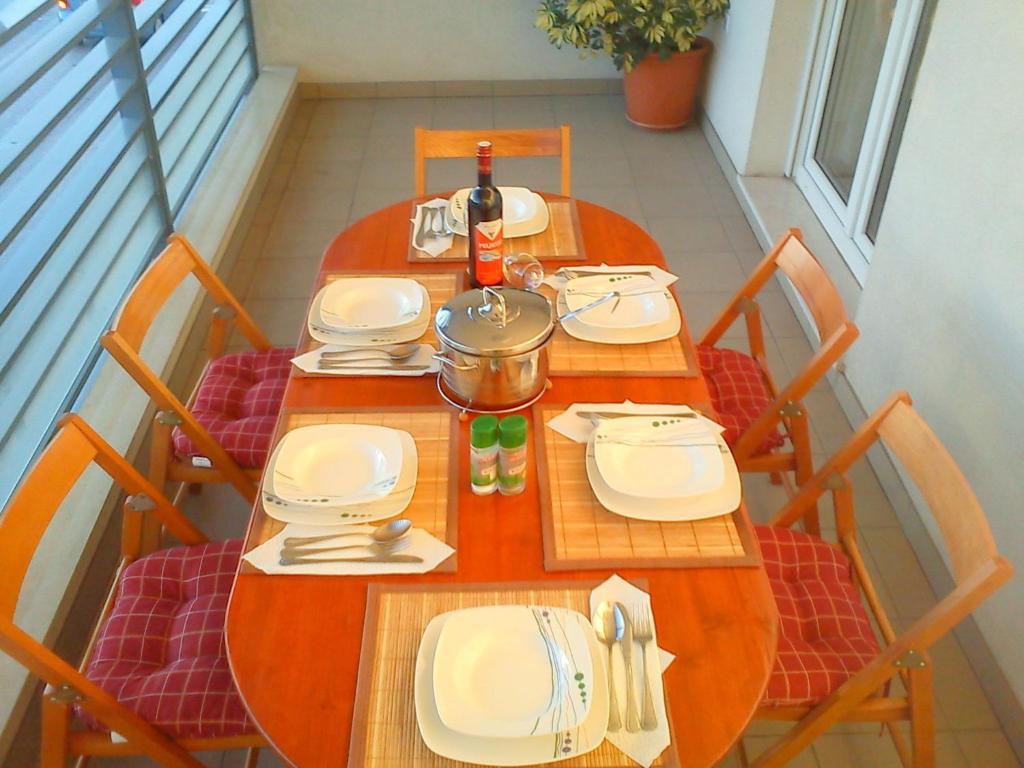a table with white plates and a bottle of wine at Zvijezda Mora Apartment in Split