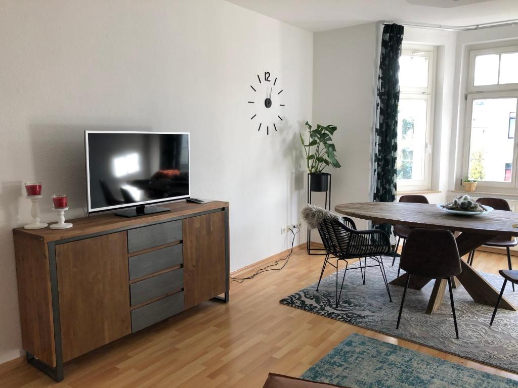 een woonkamer met een flatscreen-tv op een houten kast bij Über den Dächern des Kaßbergs in Chemnitz