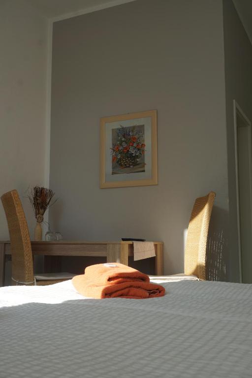 a towel sitting on a bed in a room at Pension zum Birnbaum in Brandenburg an der Havel