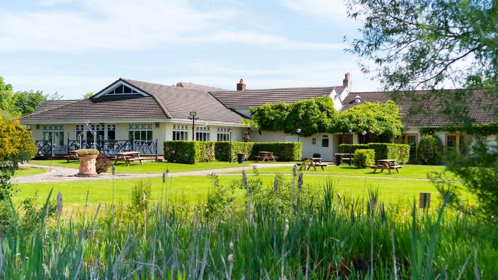 a house with a yard with tables and benches at Holt Lodge Hotel in Wrexham