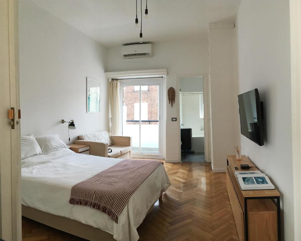 1 dormitorio con 1 cama y sala de estar con TV. en Luminous Apartment in Recoleta en Buenos Aires