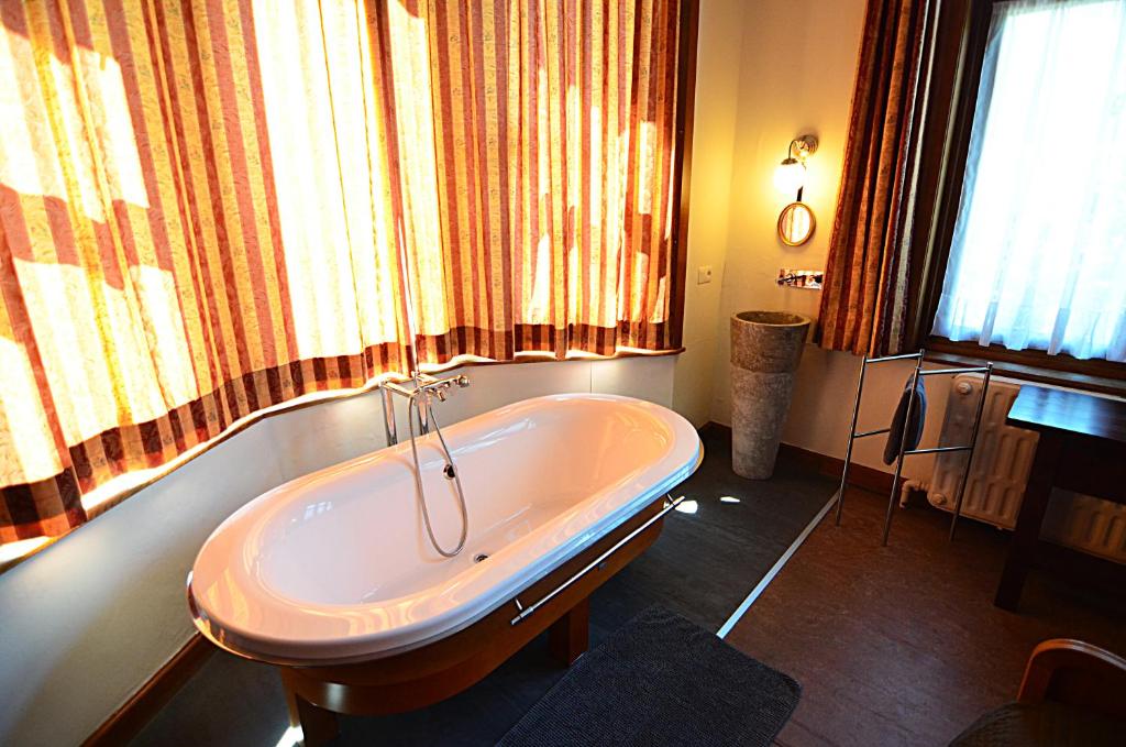 a bath tub in a bathroom with a window at La Citadine in Neufchâteau