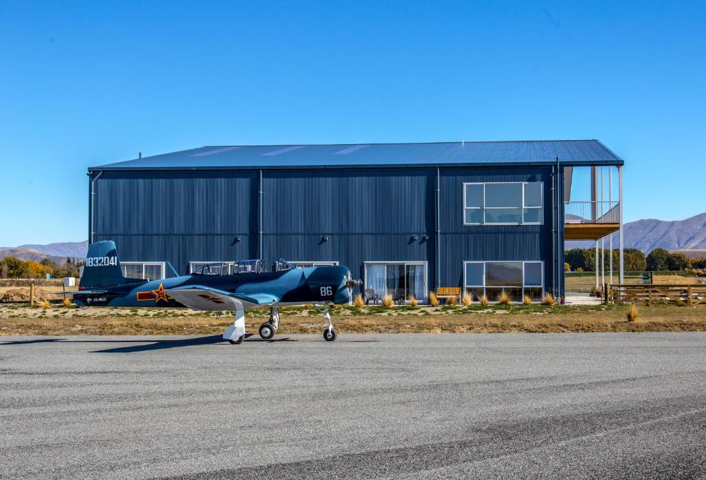 un pequeño avión estacionado frente a un hangar en Pukaki Air Lodge, en Twizel