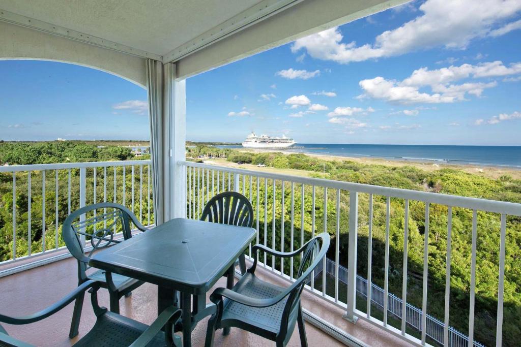 balcón con mesa, sillas y vistas al océano en Cape Canaveral Beach Resort en Cape Canaveral