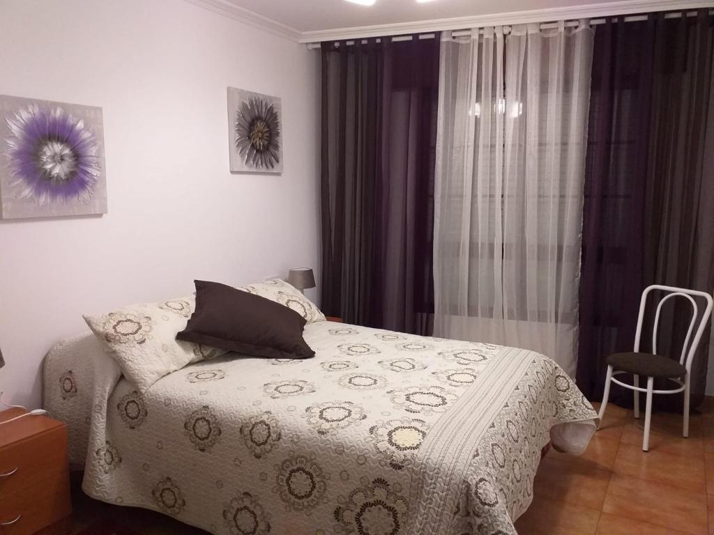 1 dormitorio con 1 cama, 1 silla y 1 ventana en Pons Caesaris en Puentecesures