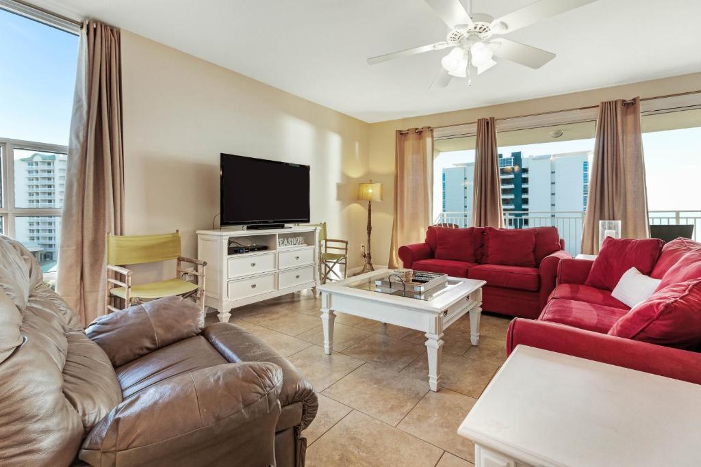 a living room with red couches and a tv at Sterling Shores III in Destin