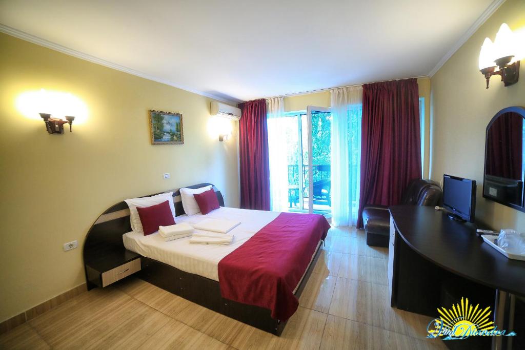a bedroom with a bed and a desk and a television at Hotel Diandra in Eforie Nord