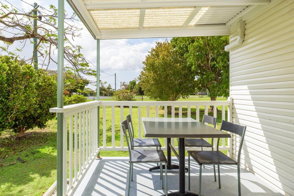 a patio with a table and chairs on a deck at Tin Can Bay's Sleepy Lagoon Motel in Tin Can Bay