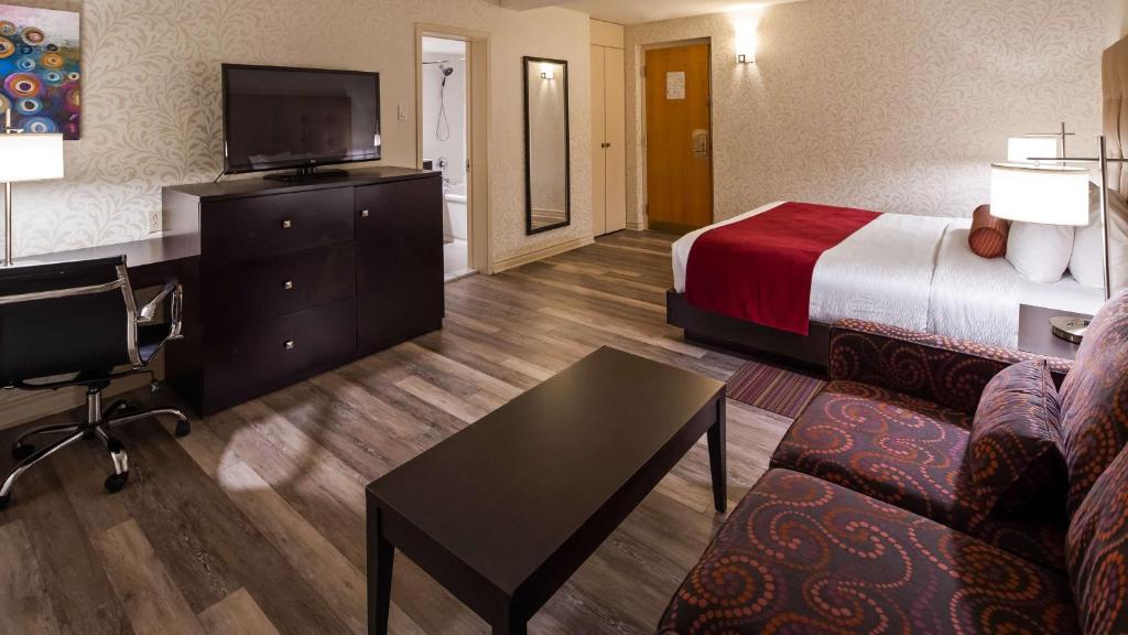 a hotel room with a bed and a television at Hotel Europa, BW Signature Collection in Montréal