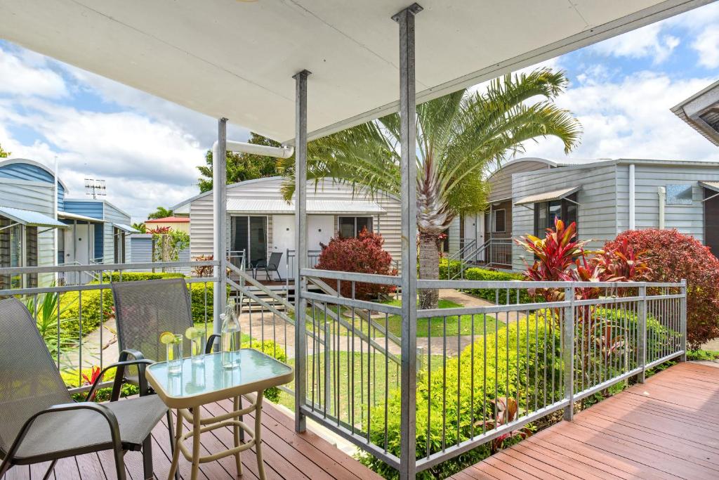 a patio with a table and chairs on a deck at Tin Can Bay's Sleepy Lagoon Motel in Tin Can Bay