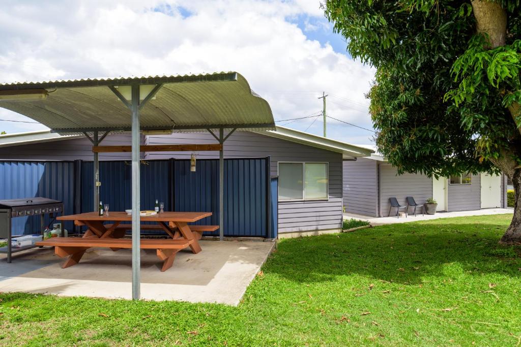 a picnic table under an umbrella in a yard at Tin Can Bay's Sleepy Lagoon Motel in Tin Can Bay