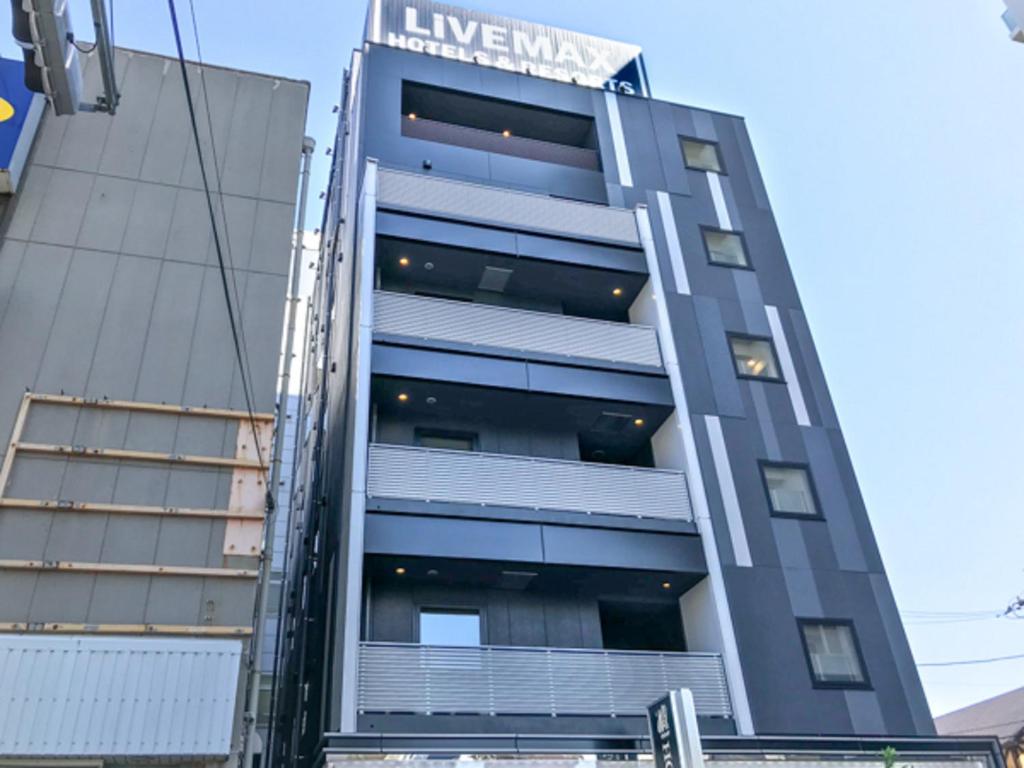 a building with a sign on the side of it at HOTEL LiVEMAX Chiba Soga-Ekimae in Chiba