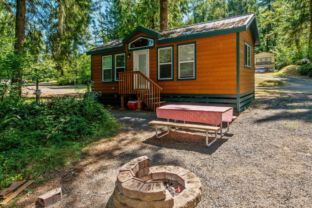 a tiny house with a fire pit in front of it at Chehalis Camping Resort Cottage 1 in Onalaska