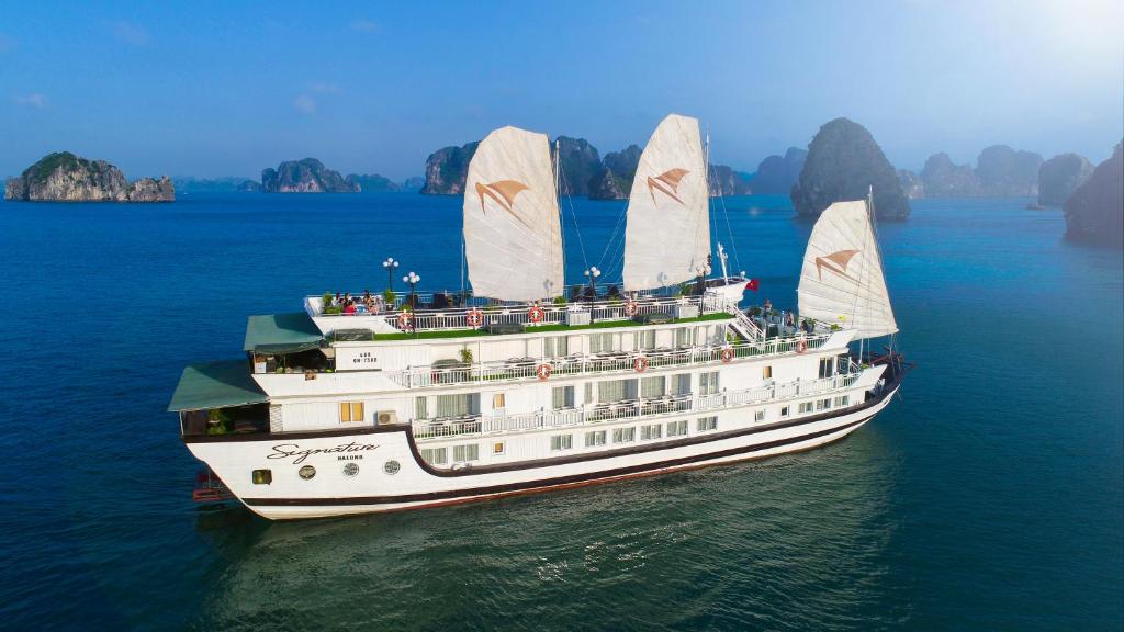 un crucero con tres velas en el agua en Signature Halong Cruise, en Ha Long